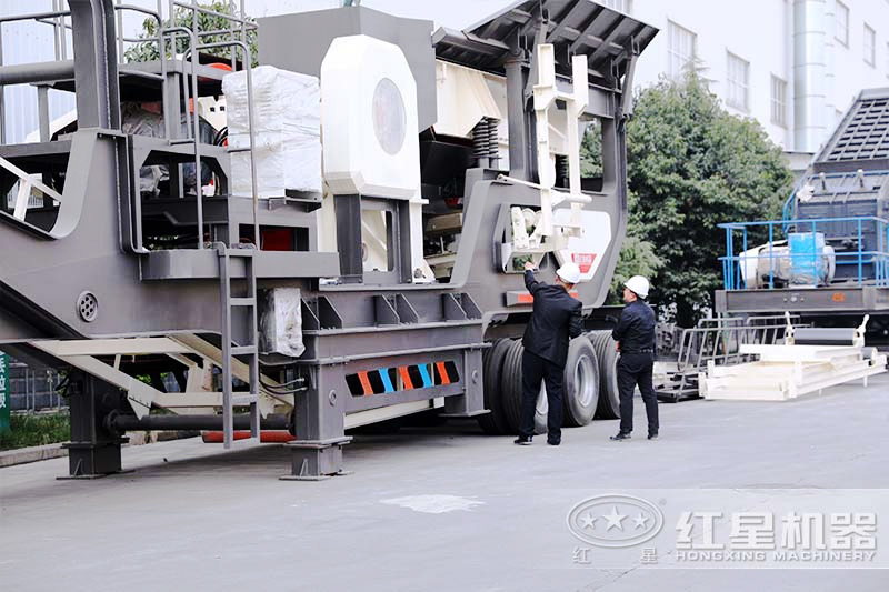 客戶參觀移動式煤矸石制砂機廠區(qū)，經(jīng)理為其介紹設備